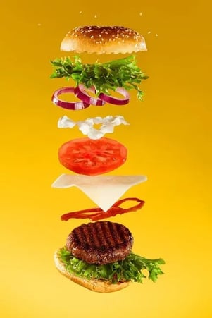 a burger shown in layers of assembly